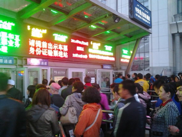 People wait at an entrance to the south railway station of Urumqi, capital of northwest China's Xinjiang Uygur Autonomous Region, after an explosion on April 30. People in the square in front of the station and nearby were evacuated immediately after the blast, and police cordoned off all entrances to the square of the station. [Photo by Gao Bo/China Daily]