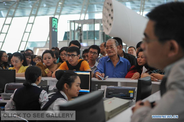 Passengers wait to alter their tickets at the airport of Shenzhen, south China's Guangdong Province, March 31, 2014.