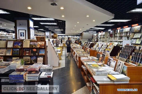 People choose books at the Sanlian Taofen Bookstore in Beijing, capital of China, at wee hours of April 9, 2014. The Sanlian Taofen Bookstore tried to open 24 hours a day on Tuesday. The trial operation will last for 10 days before the official business. (Xinhua/Wang Jingsheng)