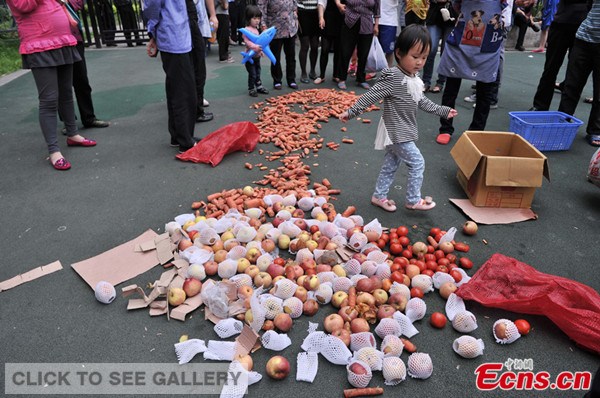 A kindergarten in Chongqing is under suspicion of preparing meals for children with bad vegetables and fruits. Nearly 100 parents gathered in front of the school on Wednesday, demanding an explanation over the case. [Photo / Chinanews.com]