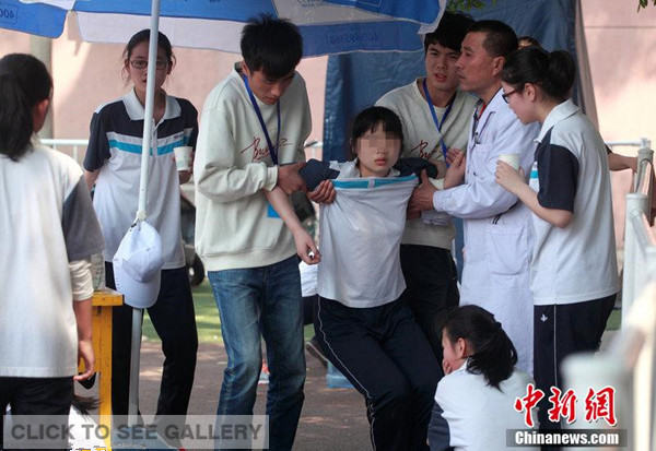 A student who nearly falls down after a long run is supported by others in Xi'an city, Shaanxi province on April 23, 2014.