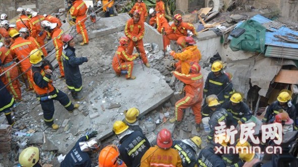 Rescuers search in debris after an old residential building collapsed in Shanghai on Sunday morning. [Photo/Xinmin.cn]