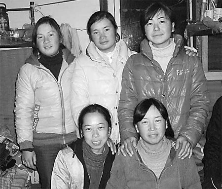 Female construction workers take a group photo at the workers dormitory. [Photo provided to China Daily]