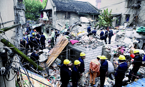 Firefighters look for survivors Sunday morning in the debris of a collapsed three-story residential building in Hongkou district. Two residents died in the collapse. Photos: Yang Hui/GT