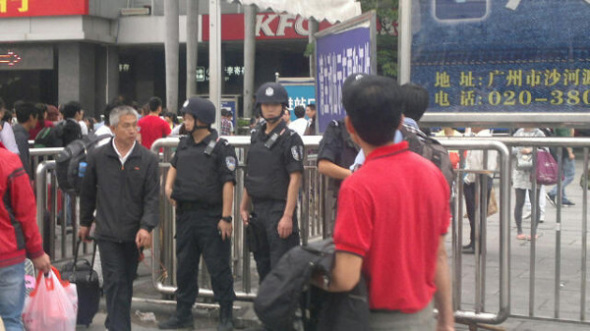 Police stand at the entrance to the railway station in Guangzhou to keep order on May 6, after a knife attack. [Photo by Zou Zai / China Daily]