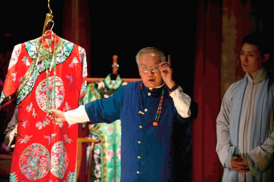 Veteran Peking Opera artist Ma Yuqi shows off the costumes worn in the performance.