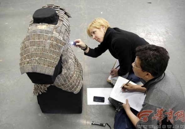 Two experts examine stone armour and record their inspection in Xi'an, Shaanxi province. The process takes over 5 hours. [Photo/hsw.cn]