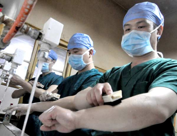 Male nurses clean themselves before going into the operation room at Handan No 2 Hospital in Hebei province. [Photo by Hao Qunying / For China Daily]