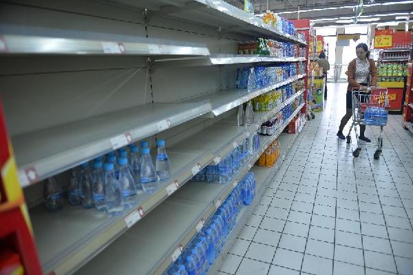 A resident purchases bottled drinkable water at a supermarket in Jingjiang City, east China's Jiangsu Province, May 9, 2014. Water supply in Jingjiang resumed on Friday after abnormal water quality was found in the Yangtze River water source, according to local authorities. The city began backup water supply at 4:40 p.m., according to the city's publicity department. (Xinhua/Shen Peng)
