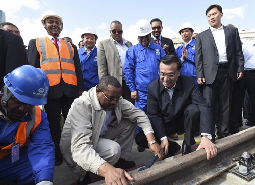 INFRASTRUCTUAL COOPERATION: Chinese Premier Li Keqiang and Ethiopian Prime Minister Hailemariam Desalegn tighten a bolt during a visit to a light railway project in Addis Ababa, Ethiopia, on May 5 (LI XUEREN)