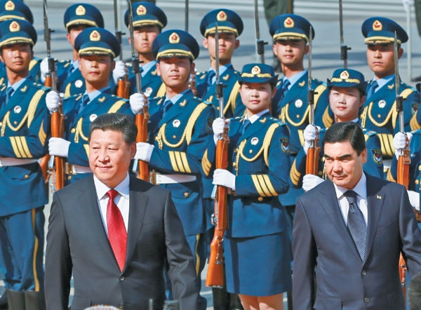 President Xi Jinping accompanies his counterpart from Turkmenistan Gurbanguly Berdymukhamedov in reviewing a guard of honor, which included women for the first time, outside the Great Hall of the People in Beijing on Monday. Photos by Feng Yongbin / China Daily