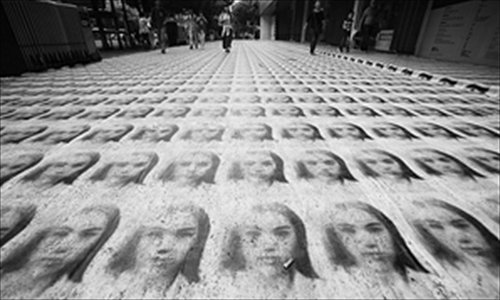 Pictured is the section of road covered with black-and-white portraits of an author in front of Ningbo Culture Center in Zhejiang province. The art installation was created for a book signing event at the center. Photo: Modern Gold Express