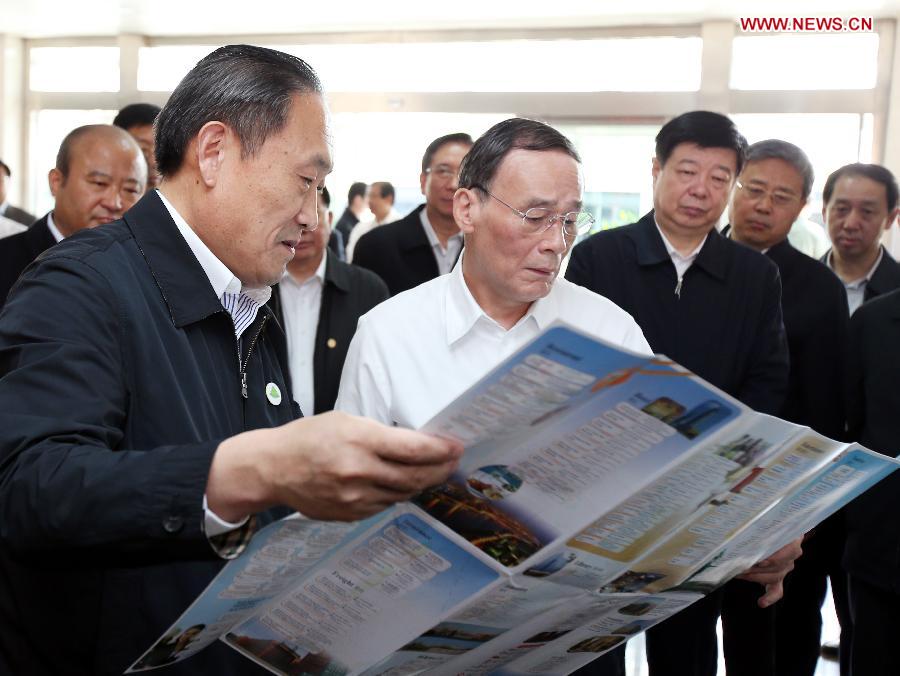 Wang Qishan (4th R), a member of the Standing Committee of the Political Bureau of the Communist Party of China (CPC) Central Committee and secretary of the Central Commission for Discipline Inspection (CCDI) of the CPC, visits the international trade service center of Linyi Wholesale City in Linyi, east China's Shandong Province, May 14, 2014. (Xinhua/Yao Dawei)