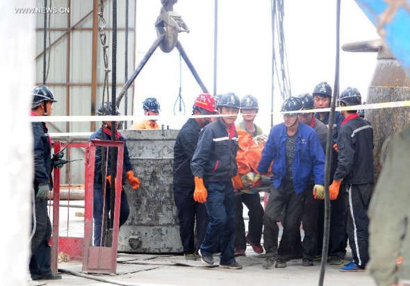 Rescuers carry the body of a victim at the Dahaize coal mine under construction by China National Coal Group Corp in Yulin City, northwest China's Shaanxi province, May 15, 2014. 
