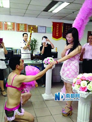 Lian proposes to his girlfriend surnamed Liao while wearing a bikini at his workplace in Dongguan, Guangdong province on May 14. Liao said yes. Photo: nandu.com
