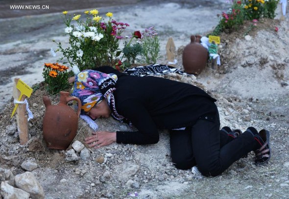 A woman cries beside a victim's grave in a cemetery in Soma of Manisa, Turkey, on May 15, 2014. The death toll in Turkey's worst coal mine disaster has risen to 292 after eight more bodies were found in the western town of Soma, Energy Minister Taner Yildiz said late on Friday. (Xinhua/Lu Zhe)