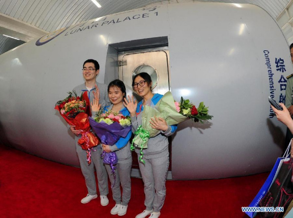Captain Xie Beizhen (C) and crew members Wang Minjuan (R) and Dong Chen (L) of the Moon Palace 1 pose for photos after living in the closed lab for 105 days in Beijing, capital of China, May 20, 2014.  (Xinhua/Gong Lei) 