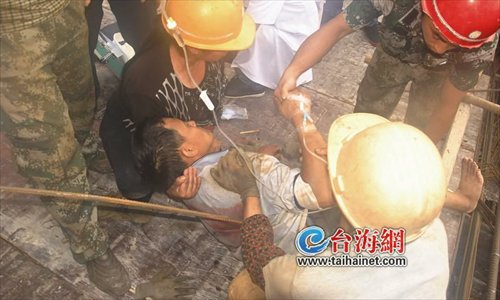 Firefighters and workers rescue Xiang Shihua, a construction worker in Longyan, Fujian province, after he was impaled by a falling metal rod on a construction site May 17. Photo: taihainet.com