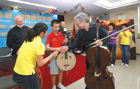 A cellist from the Philadelphia Orchestra shakes hands with a blind student at the Dongcheng District Special Education School in Beijing in 2013. Photo provided to China Daily
