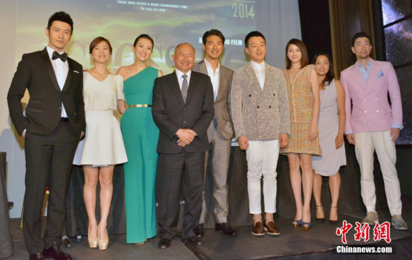 Hong Kong director John Woo and the cast of The Crossing pose for photos at the ongoing Cannes Film Festival on May 18, 2014. [Photo: China News Service/ Long Jianwu]