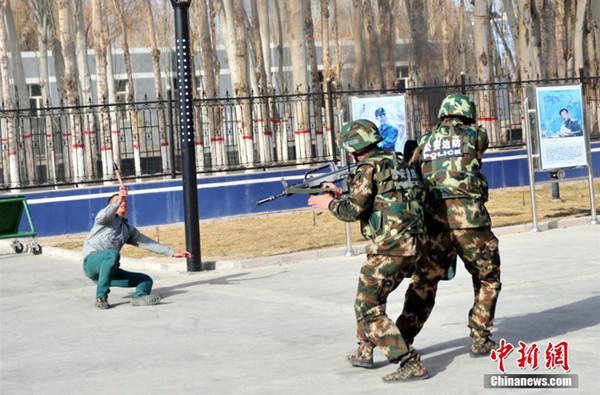 Police attending an anti-terror drill aim at a suspect at a border police station Xinjiang in this April, 2014 file photo. [Photo/Chinanews.com]