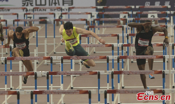 China's Xie Wenjun (center) clears a hurdle to win the men's 110m hurdles in the 2014 IAAF World Challenge Beijing meet at the National Stadium in Beijing on Wednesday, May 21, 2014. [Photo/China News Service]