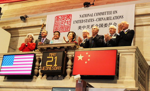 Five former US ambassadors to China and members of the National Committee on US-China Relations applaud after former ambassador Gary Locke (third from left) rings the closing bell at the New York Stock Exchange on Wednesday. The committee brought together the former ambassadors to mark the 35th anniversary of the opening of US-China diplomatic relations. [LIU ZHENG / CHINA DAILY]