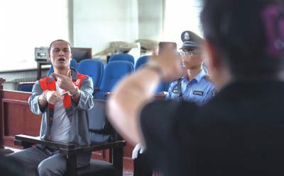 Zhang Zhiguo answers questions in sign language during his court appearance on May 22, 2014. [Photo: Beijing Times]