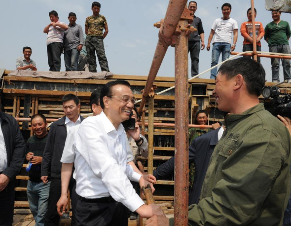 Chinese Premier Li Keqiang (C, front) talks with migrant workers at Derun Drainage Co., Ltd. in Chifeng City, north China's Inner Mongolia Autonomous Region, May 22, 2014. Li paid an inspection tour to Chifeng City on Thursday and Friday. (Xinhua/Xie Huanchi)