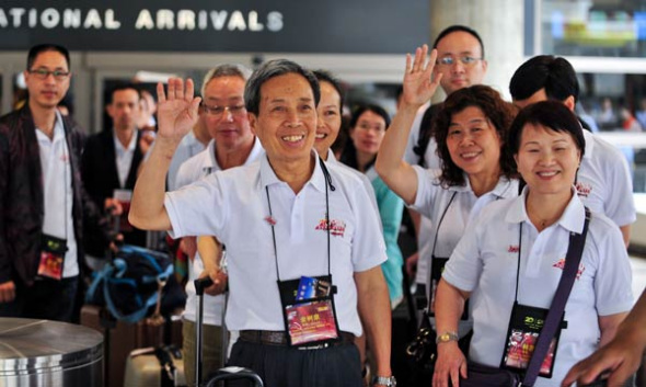 Members of a 7,000-member Chinese tour group leave an airport terminal in Los Angeles on Thursday. It is the largest single group of Chinese people ever to visit the United States. Zhang Chaoqun / Xinhua 