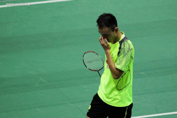 China's Du Pengyu reacts during the men's singles match against Japan's Momota Kento in the semifinal of Thomas Cup badminton championship in New Delhi, capital of India, May 23, 2014. Du Pengyu lost the match 1-2 and China fail to advance to the final with 0-3. (Xinhua/Zheng Huansong)