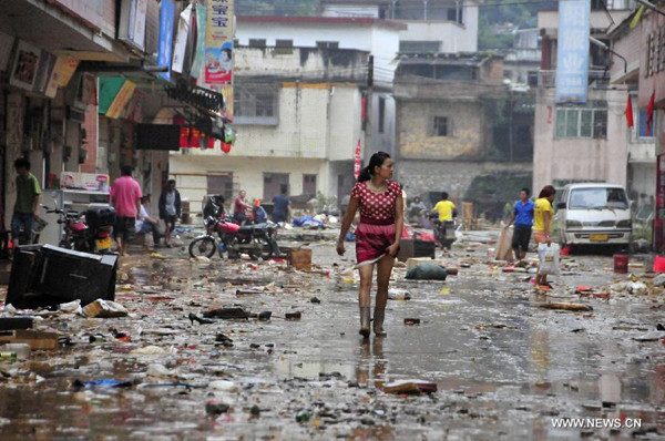 Residents go on the street after a flood subsided in Shitan Town of Qingyuan, south China's Guangdong Province, May 24, 2014. [Photo/Xinhua]