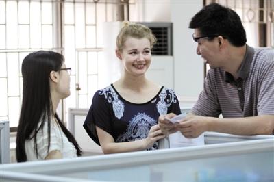 A foreign employee from Britain works at Foshan City's Foreign Trade and Economic Cooperation Bureau communicating with her Chinese colleagues, in Foshan, south China's Guangzhou Province. [Photo: New Express]