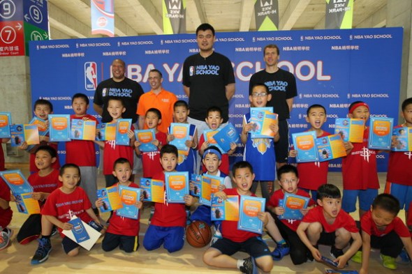 Yao Ming, David Shoemaker and coaches of the NBA Yao School pose with students at the graduation ceremony of the first-phase of the program at the Wukesong Hi-Park in Beijing, May 24. [Photo provided to chinadaily.com.cn]
