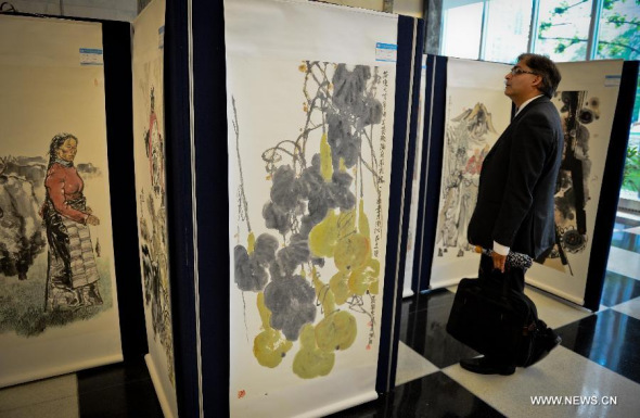 A visitor looks at paintings on display during an exhibition of Chinese paintings and calligraphy works, at the United Nations headquarters in New York, on May 27, 2014. [Xinhua/Niu Xiaolei]