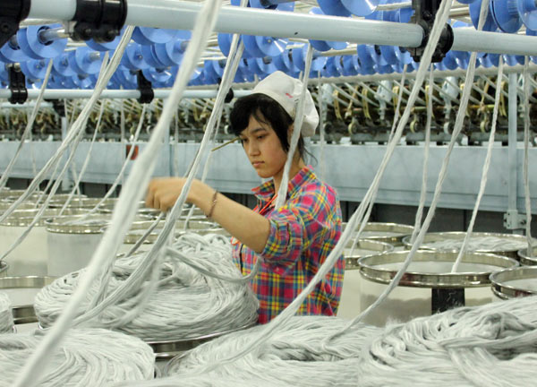 A woman works at the factory of Huafu Top Dyed Melange Yarn Co in Aksu in southern Xinjiang. More than 95 percent of the workers on the production lines are from the Uygur ethnic group and most are recruited locally. GAO BO / CHINA DAILY 