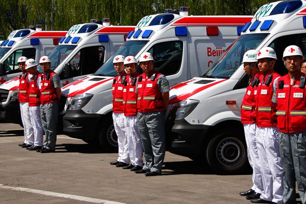 Beijing Red Cross emergency medical team members line up near their ambulances at a launching ceremony near the Bird's Nest in Beijing on Wednesday. KUANG LINHUA / CHINA DAY