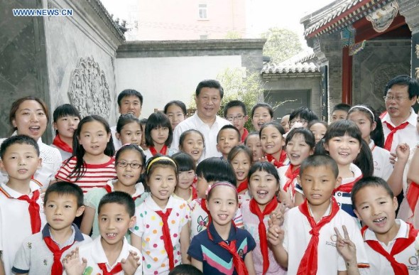 Chinese President Xi Jinping poses for a group photo with students and teachers during his visit at Beijing Haidian National Primary School in Beijing, capital of China, May 30, 2014. Xi attended an activity to celebrate the upcoming International Children's Day at the primary school. (Xinhua/Ju Peng)