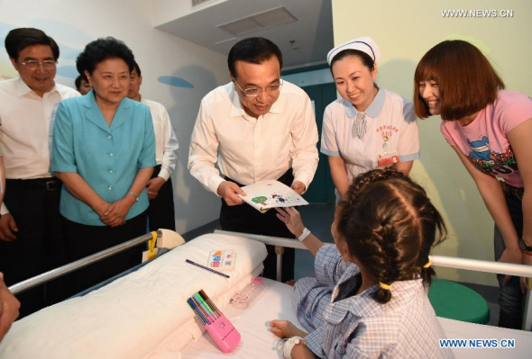 Chinese Premier Li Keqiang receives a painting created by a child when he visits the Bayi Children's Hospital in Beijing, capital of China, May 30, 2014. Li expressed his wishes to children ahead of the International Children's Day. (Xinhua/Ma Zhancheng)