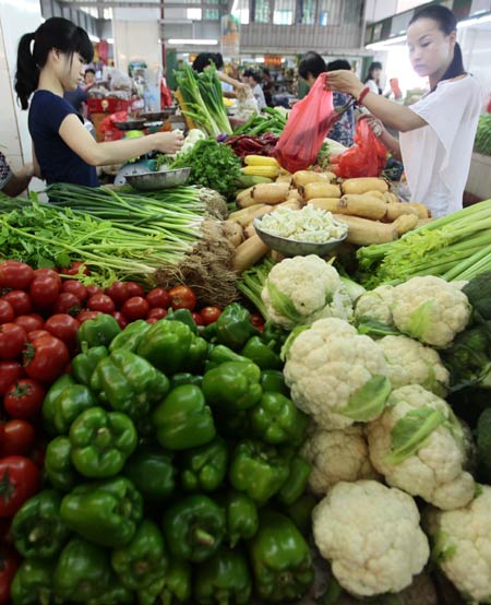 Residents choose vegetables to buy at a market in Sanya in April. Provided to China Daily
