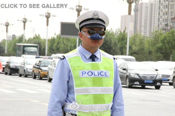 A traffic police, wearing an anti-smog nasal air filter, is on duty in Shijiazhuang of Hebei province. [Photo/ Weibo account of Hebei Daily]