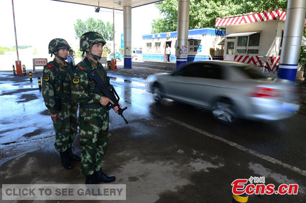 Two armed police officers are at one of check points on expressways and roads that connect Beijing with the neighboring cities and provinces on May 20, 2014. More than 100 armed police officers have been deployed for 17 check points since Tuesday and they work a 24-hour shift till mid June. [Photo: CFP]