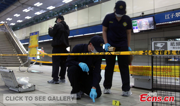 Police officers work at the scene of a knife attack on a subway platform in Taipei on May 21, 2014. [Photo: China News Service/Liu Shuling]