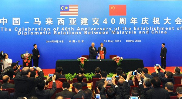 Chinese Premier Li Keqiang (center R) and Malaysian Prime Minister Najib Razak (center L) sign a joint communique at the celebration of the 40th anniversary of the establishment of diplomatic relations between China and Malaysia in Beijing, capital of China, May 31, 2014. (Photo/Xinhuan)