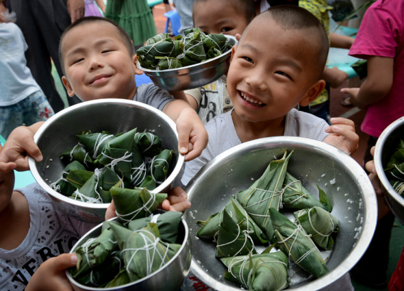 Children show off their Zongzi making efforts at a kindergarten in Puyang, Henan province. Tong Jiang / for China Daily