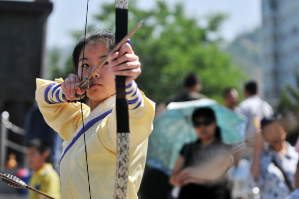 Wang Yawen practices arrow shooting, which is one of the traditions of Duanwu, near the Yellow River in Lanzhou, Gansu province. Chen Bin / Xinhua