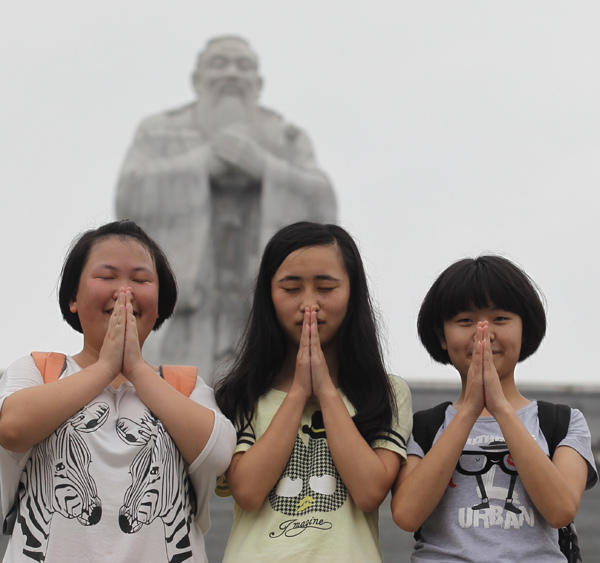 Students pray for good results in the upcoming gaokao in front of a statue of Confucius in Guiyang, Guizhou province, on Wednesday. China's national college entrance exam will be held on Saturday and Sunday. Zhu Xingxin / China Daily