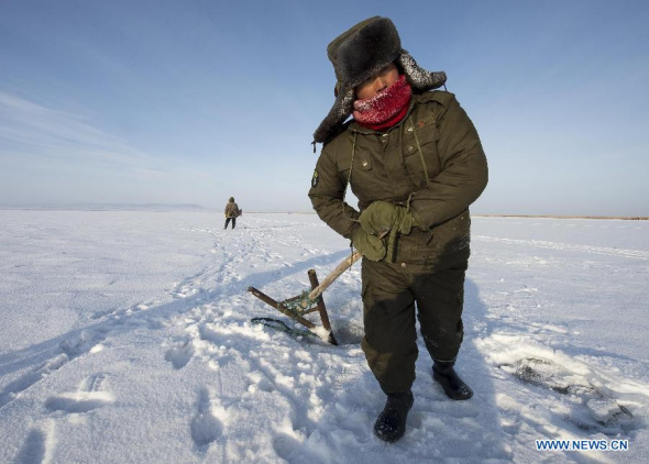 A fisherman pulls net on the Ulunggur Lake in Fuhai County, northwest China's Xinjiang Uygur Autonomous Region, Jan. 19, 2014. [Photo/Xinhua]