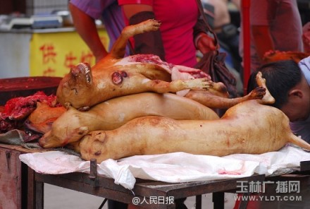 The undated photo shows a man is cutting dog meat at a stall in Yulin, Guangxi. [Photo: the official Sina Weibo account of People's Daily]