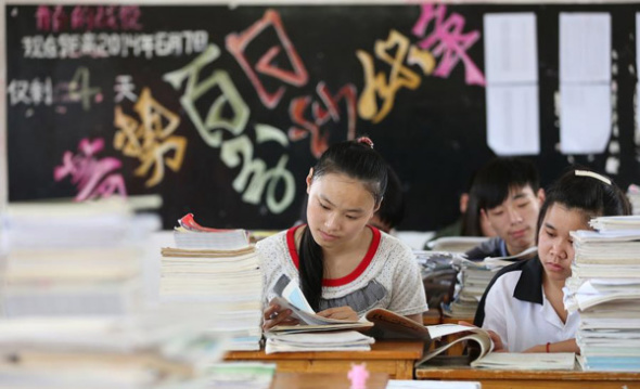 Grade 3 students from Jingshan school for migrant children revise before the college entrance examination, or gaokao, in Jinjiang city, Fujian province, June 4, 2014. Some 3,600 migrant students will sit the exam in Fujian this year.[Photo/Xinhua]